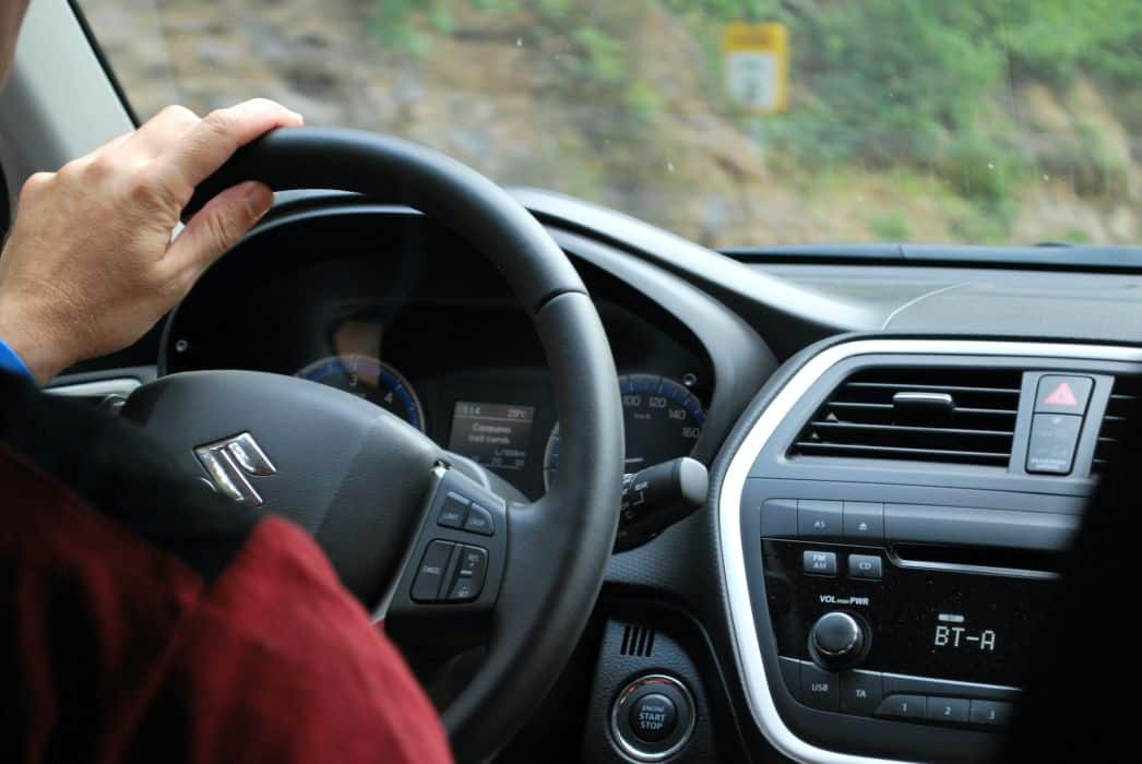 A person holding steering wheel of a car